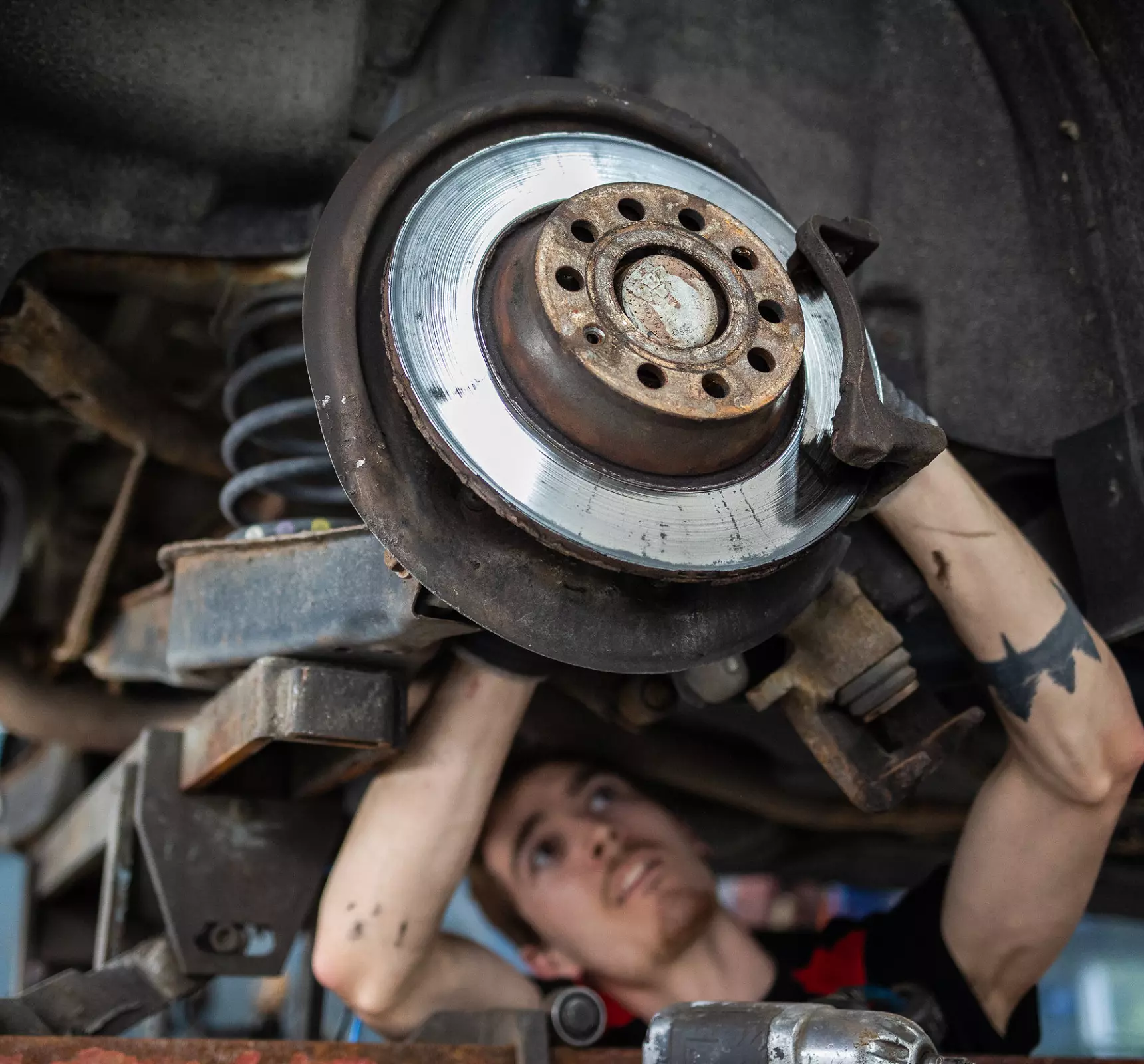 Mekaniker som arbeider med bremsene på en bil